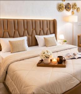 a large bed with a tray with flowers and candles at Peaceful Studio with Kitchen in New Delhi