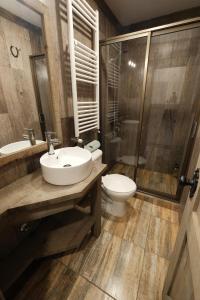 a bathroom with a sink and a toilet and a shower at Casa Oxidada in Puerto Natales