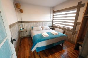 a bedroom with a bed with two towels on it at Casa Oxidada in Puerto Natales