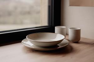 a bowl on a table next to two cups at Hüttenchalets Rhön in Geisa +24 photos