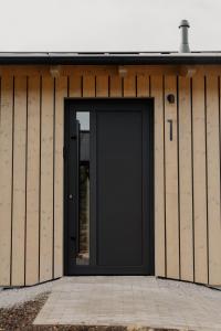 a black door on the side of a building at Hüttenchalets Rhön in Geisa