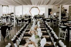 a banquet hall with tables and chairs with white tables and white chairs at Waterfront Hotel in Prairie du Chien