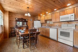 a kitchen with a table and white appliances at Echo Motel in Old Orchard Beach
