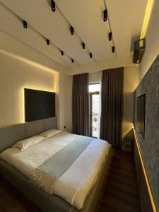 a bedroom with a large bed and a window at Tashkent city Gardens E2 block in Tashkent