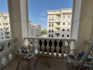 a balcony with chairs and a view of a city at Tashkent city Gardens E2 block in Tashkent