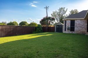 a yard with a fence and a house at Bluebonnet Retreat in Flower Mound