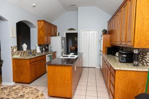 a large kitchen with wooden cabinets and counters at Bluebonnet Retreat in Flower Mound