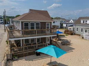 a house with a deck and an umbrella at Echo Motel in Old Orchard Beach