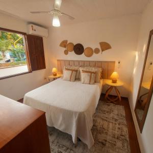 a bedroom with a white bed and two tables at Residência Thomas in Itacaré +44 photos