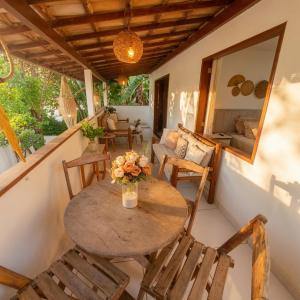 a porch with a table and chairs and a couch at Residência Thomas in Itacaré