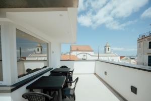 a balcony with tables and chairs and a view of the city at Aragonese Apartments in Casa Chiaiozza
