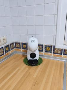 a white robot sitting on a floor in a room at El Retiro de Albarreal - Chalet 3 hab, Aire Acondicionado y Entrada Piscina Gratuita in Albarreal de Tajo +29 photos