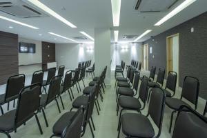 a room with a bunch of chairs in it at Flat Completo no Centro de Itaboraí Promenade Prime in Itaboraí +42 photos