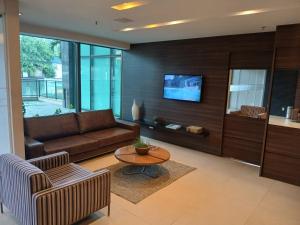 a living room with a couch and a table at Flat Completo no Centro de Itaboraí Promenade Prime in Itaboraí