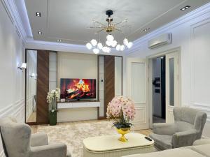 a living room with a fireplace and a tv at Tashkent city Gardens E2 block in Tashkent
