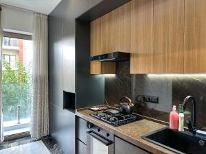 a kitchen with a stove top oven next to a sink at Tashkent city Gardens E2 block in Tashkent