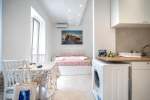 a kitchen with a table and a bed in a room at Aragonese Apartments in Casa Chiaiozza