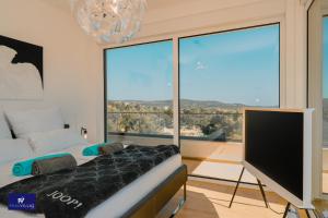 a bedroom with a bed and a flat screen tv at Primosten Hills West - Branded Luxury Villa in Primošten