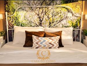 a white bed with a metal headboard and pillows at Casa Do Cairo - Rehab City in Cairo