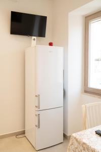 a white refrigerator with a television on top of it at Aragonese Apartments in Casa Chiaiozza