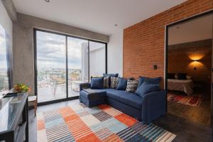 a living room with a blue couch and a brick wall at TORRE ARCARTI Internet alta velocidad y estacionamiento in San Baltasar