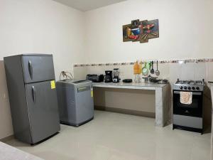 a kitchen with a stove and a refrigerator and a counter at Aruma House - Departamento de 2 Dormitorios in Tena
