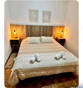 a bedroom with a bed with two slippers on it at La mejor opcion en BA in Buenos Aires