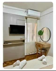 a living room with a television and a desk with towels at La mejor opcion en BA in Buenos Aires