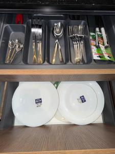 two white plates and utensils in a drawer at Triple Tower 23eme étage La vue 329 gare tgv & plage 3min in Tangier +16 photos