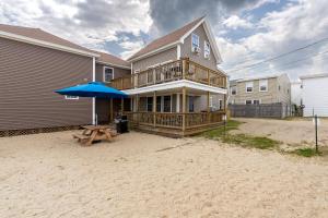 a house with an umbrella and a picnic table at Echo Motel in Old Orchard Beach