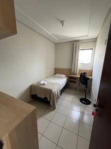 a small bedroom with a bed and a window at Hotel Piracema Caruaru in Caruaru