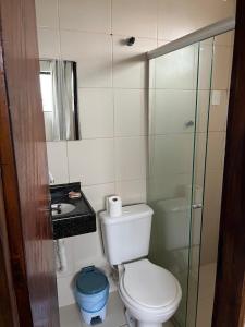 a bathroom with a toilet and a sink and a shower at Hotel Piracema Caruaru in Caruaru
