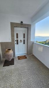 a bathroom with a door with a view of the ocean at Κάρτ Ποστάλ Τρίκερι- Carte Postale Trikeri in Trikeri
