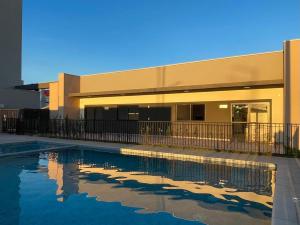 a swimming pool in front of a building at Apartamento próximo ao Aeroporto e Curitiba in São José dos Pinhais +5 photos
