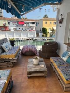 a patio with couches and tables on a balcony at Casa con embarcadero in Los Mártires