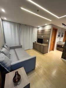 a living room with a couch and a tv at Flat Completo no Centro de Itaboraí Promenade Prime in Itaboraí