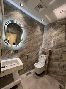 a bathroom with a toilet and a sink and a mirror at Janjua lodges Murree in Murree