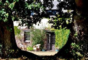 una sedia seduta di fronte a una casa in pietra di Gite de la Ruaudais a Bréal-sous-Montfort