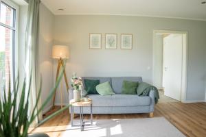 a living room with a blue couch and a table at Ferienwohnung Landblick in Borken