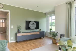 a living room with a tv on a wall at Ferienwohnung Landblick in Borken