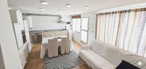 a living room with a white couch and a kitchen at Casa con embarcadero in Los Mártires