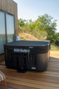a hot tub sitting on the deck of a house at L'Instant Des Amants in Sorèze +3 photos