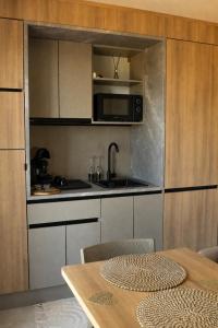 a kitchen with a table and a sink and a microwave at L'Instant Des Amants in Sorèze