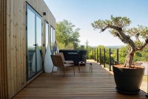 a deck with a tree and a grill on it at L'Instant Des Amants in Sorèze
