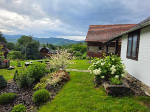 a yard with a house and some bushes and flowers at Ya VDOMA in Kozmacz