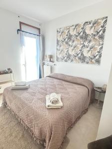 a bedroom with a bed with a blanket and a window at La tenuta di Greta in Canino