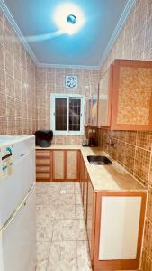 a kitchen with a white refrigerator and a sink at شقق أماسي الواحة بالعقيق in Al ‘Aqīq
