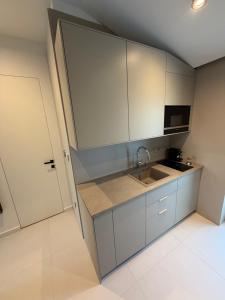 a kitchen with white cabinets and a sink at Vista on the sea in Ankaran