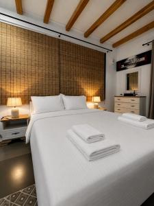 a bedroom with a large white bed with two towels on it at Villa Velvet Chios in Chios