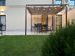 a patio with a table and chairs under a pergola at Luxe House Odessa Private Jacuzzi BBQ, Free Parking in Odesa